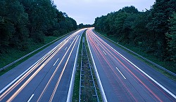 Empty roadway between two tree filled areas